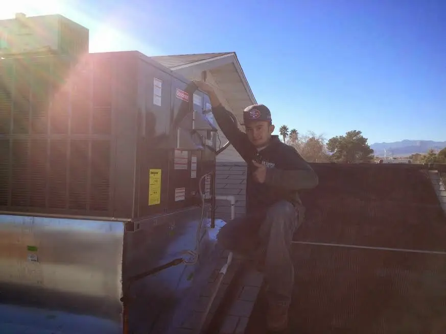 HVAC technician performing Air Duct Cleaning on a rooftop unit in Temple